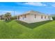 Well-maintained house exterior with grassy lawn and covered patio at 51 Sun Dunes Cir, Ponce Inlet, FL 32127