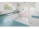 View of kitchen with teal countertops, white appliances, and breakfast bar at 51 Sun Dunes Cir, Ponce Inlet, FL 32127