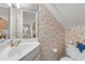 Small bathroom with white vanity, toilet, and patterned wallpaper at 1111 Hill St # U3, New Smyrna Beach, FL 32169