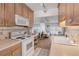 Kitchen with wood cabinets, white appliances, and ocean view at 1111 Hill St # U3, New Smyrna Beach, FL 32169