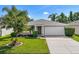 One-story home with a white garage door and landscaped lawn at 5321 Cordgrass Bend Ln, Port Orange, FL 32128