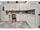 Bright laundry room with white cabinets and dark gray tile backsplash at 407 Douglas St, New Smyrna Beach, FL 32168