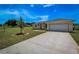 House exterior showcasing a two-car garage and a spacious front yard at 15190 Cr-565A, Clermont, FL 34711