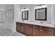Double vanity bathroom with dark brown cabinets, quartz countertops, and large mirrors at 15190 Cr-565A, Clermont, FL 34711