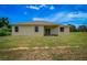 Tan house exterior with covered patio and grassy yard at 15190 Cr-565A, Clermont, FL 34711