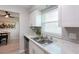 Bright kitchen featuring white cabinets, marble countertops and a view to dining area at 3750 S Atlantic Ave # 180, Daytona Beach Shores, FL 32118