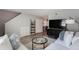 Open living room with sectional sofa, a glass coffee table, and stairs to upper level at 3750 S Atlantic Ave # 180, Daytona Beach Shores, FL 32118
