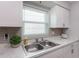 Clean kitchen with white cabinets, marble countertops, and a double sink at 3750 S Atlantic Ave # 180, Daytona Beach Shores, FL 32118