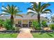 Inviting front porch with palm trees and brick walkway at 3650 Pepper Ln, New Smyrna Beach, FL 32168