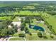 Aerial view of a property with a pond, riding arena, and main house at 3650 Pepper Ln, New Smyrna Beach, FL 32168