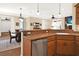 Open kitchen with island, stainless steel dishwasher, and breakfast bar at 3650 Pepper Ln, New Smyrna Beach, FL 32168
