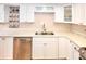 Modern kitchen with white cabinets, stainless steel dishwasher, and double sink at 4175 S Atlantic Ave # 4120, New Smyrna Beach, FL 32169