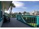 Relaxing deck overlooking neighborhood, featuring teal railings and comfy adirondack chairs at 320 Due East St, New Smyrna Beach, FL 32169