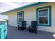 Charming deck with two black adirondack chairs and a small side table at 320 Due East St, New Smyrna Beach, FL 32169