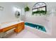 Bathroom with wood vanity, teal tub, and arched window at 1780 Otisco Way, Winter Springs, FL 32708