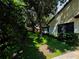 Landscaped side yard with mature trees and hedges at 1780 Otisco Way, Winter Springs, FL 32708