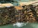 Stone waterfall feature cascading into the pool at 1780 Otisco Way, Winter Springs, FL 32708