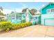Teal house with a garage and manicured landscaping at 412 S Peninsula Ave, New Smyrna Beach, FL 32169