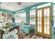 Sunroom featuring yellow doors and a relaxing daybed at 412 S Peninsula Ave, New Smyrna Beach, FL 32169