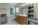 Clean bathroom with wood vanity, tiled floor, and decorative wall art at 412 S Peninsula Ave, New Smyrna Beach, FL 32169