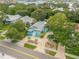 Aerial view of a teal home with a circular driveway, landscaping, and a waterfront location at 412 S Peninsula Ave, New Smyrna Beach, FL 32169