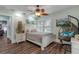 Bedroom with a white bed frame, ceiling fan, and wicker hanging chair at 412 S Peninsula Ave, New Smyrna Beach, FL 32169