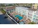 Aerial view of a beachside community featuring a pool, patio furniture, and multiple buildings at 3509 S Atlantic Ave # 209, New Smyrna Beach, FL 32169