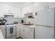Efficient galley kitchen, white cabinets, and full-size appliances at 3509 S Atlantic Ave # 209, New Smyrna Beach, FL 32169