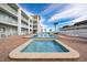 Relaxing pool and spa area with brick patio and building in the background at 3509 S Atlantic Ave # 209, New Smyrna Beach, FL 32169