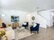 Living room with white sofa and blue armchairs, and a view of the staircase at 3975 Willowbrook Dr, Edgewater, FL 32141