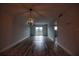 Open living area with chandelier, wood-look floors, and balcony access at 101 N Riverside Dr # 4140, New Smyrna Beach, FL 32168