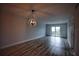 Open living area with chandelier, wood-look floors, and balcony access at 101 N Riverside Dr # 4140, New Smyrna Beach, FL 32168