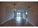 Open living area with chandelier, wood-look floors, and balcony access at 101 N Riverside Dr # 4140, New Smyrna Beach, FL 32168