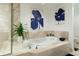 Spa-like bathroom with soaking tub, blue artwork, and a glass enclosure at 241 Riverside Dr # 2007, Holly Hill, FL 32117