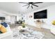 Open living room with white sofas, large TV, and a ceiling fan at 241 Riverside Dr # 2007, Holly Hill, FL 32117