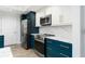 Modern kitchen with teal cabinets, quartz countertops, and stainless steel appliances at 241 Riverside Dr # 2007, Holly Hill, FL 32117