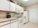 Bright kitchen with white cabinets, and a side door to the outside at 1805 Turnbull Lakes Dr, New Smyrna Beach, FL 32168