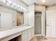 Bathroom with double vanity, large mirror, and shower at 1805 Turnbull Lakes Dr, New Smyrna Beach, FL 32168