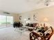 Bright living room featuring a comfy sofa, glass coffee table and ceiling fan at 1805 Turnbull Lakes Dr, New Smyrna Beach, FL 32168