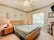 Bedroom with wood-toned furniture, striped bedding, and window at 1805 Turnbull Lakes Dr, New Smyrna Beach, FL 32168