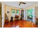 Home office with hardwood floors, built-in shelving, and adjacent sunroom at 1206 S Riverside Dr, New Smyrna Beach, FL 32168
