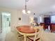Open concept dining area with a wooden table and chairs, adjacent to kitchen and laundry at 426 Bouchelle Dr # 303, New Smyrna Beach, FL 32169