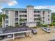 Three-story condo building with green roof, parking, and landscaping at 426 Bouchelle Dr # 303, New Smyrna Beach, FL 32169