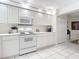 White kitchen with appliances and view into dining area at 426 Bouchelle Dr # 303, New Smyrna Beach, FL 32169