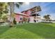 Two-story pink house with a large backyard at 300 Quay Assisi Ct, New Smyrna Beach, FL 32169