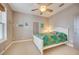 Cozy bedroom with white bed frame, ceiling fan, and carpeted floor at 300 Quay Assisi Ct, New Smyrna Beach, FL 32169