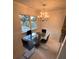 Dining area with glass-top table and four black chairs under chandelier at 840 Center Ave # 840, Daytona Beach, FL 32117