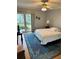 Bedroom with a ceiling fan, large windows and blue area rug at 721 S Beach St # 214A, Daytona Beach, FL 32114