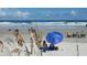 Couple relaxing on the beach under a blue umbrella at 11 Andrea Dr, New Smyrna Beach, FL 32168