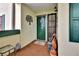 Condo entryway with green door, outdoor seating, and decor at 731 Marina Point Dr # 7310, Daytona Beach, FL 32114